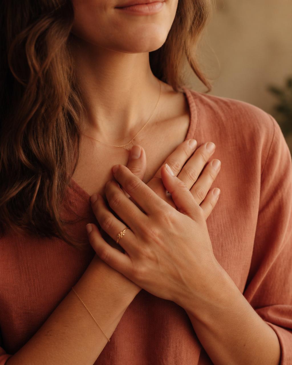 Hands resting over the heart in a somatic embodiment practice